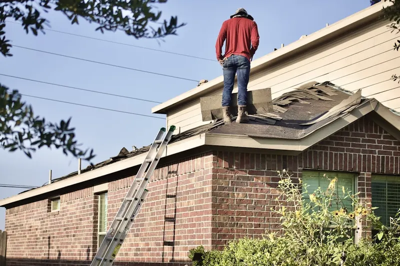 Professional roofer working on a residential roof in East Village
